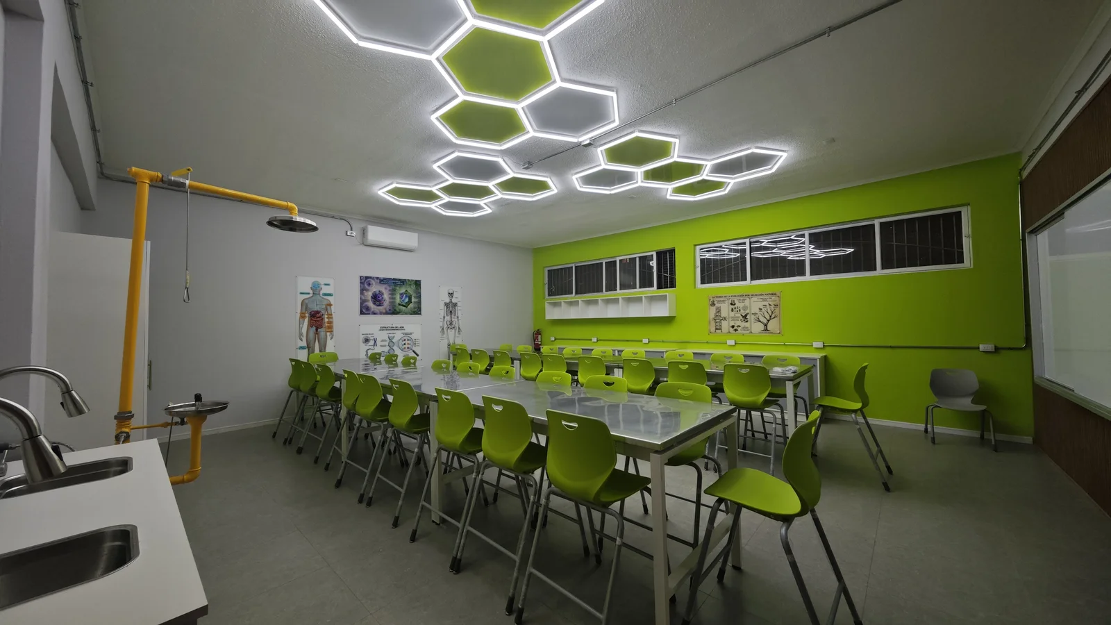Laboratorio de biología del Liceo Católico Atacama con iluminación hexagonal y sillas verdes